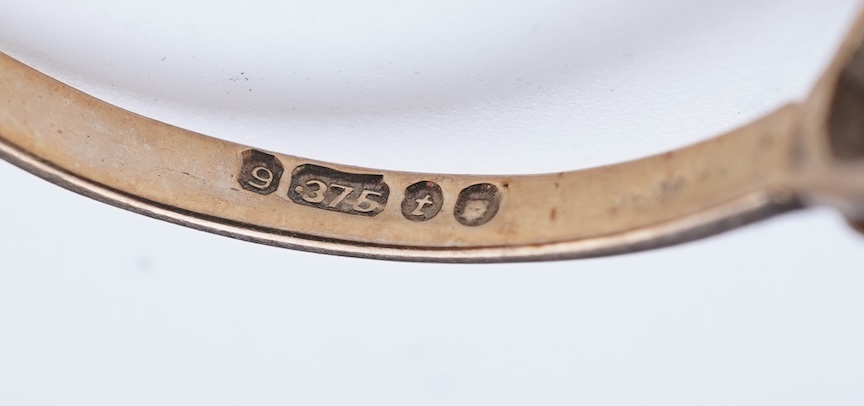 A collection of four rings and a pendant